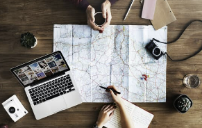People with a map and laptop planning travel
